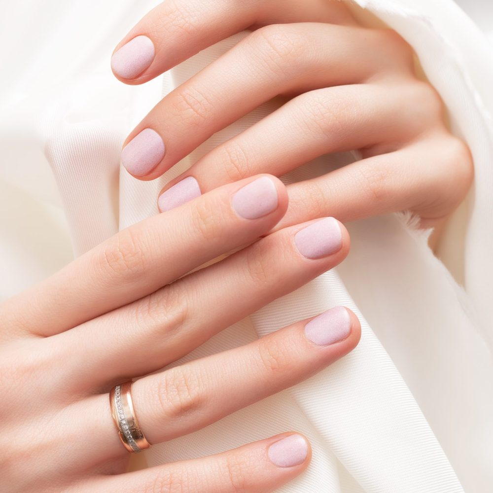 Pink nail design. Female hands with glitter manicure